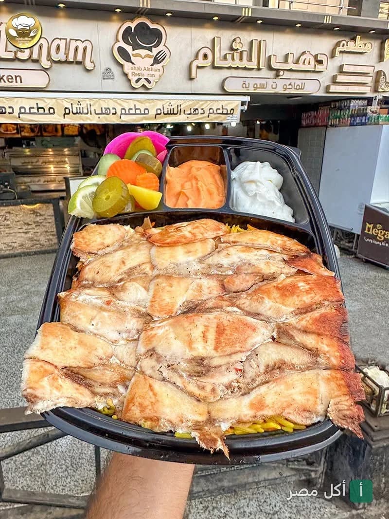 وجبة شاورما دجاج في علبة تيك أواي أمام واجهة مطعم دهب الشام في عين شمس.