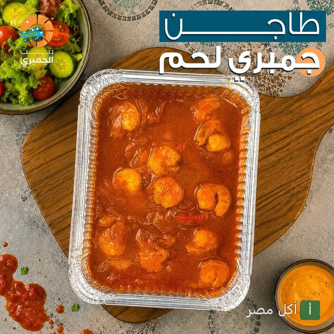 طاجن جمبري بصلصة الطماطم في مطعم بيت الجمبري بعين شمس مع طبق سلطة خضراء.