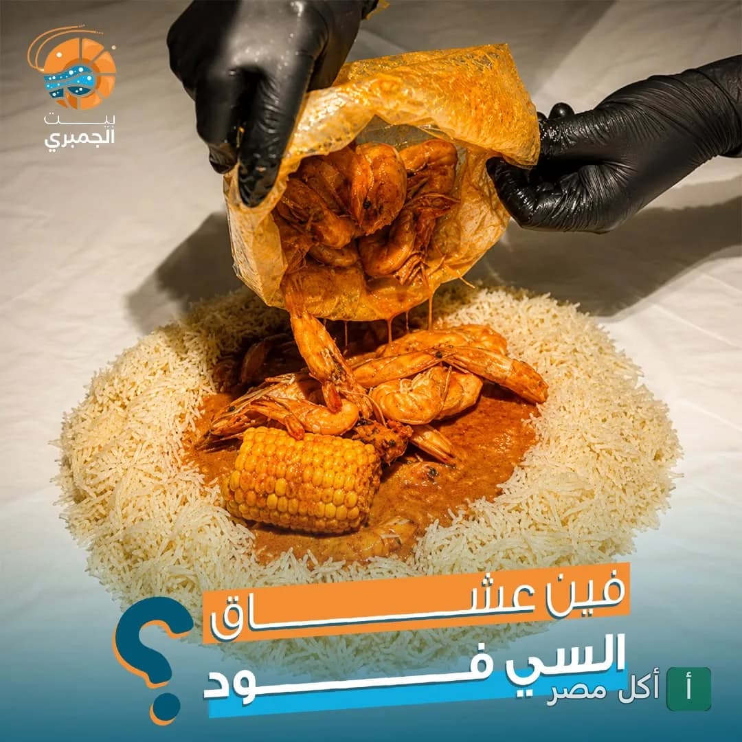 تقديم وجبة جمبري بصوص المأكولات البحرية والذرة على أرز أبيض في مطعم بيت الجمبري بعين شمس.