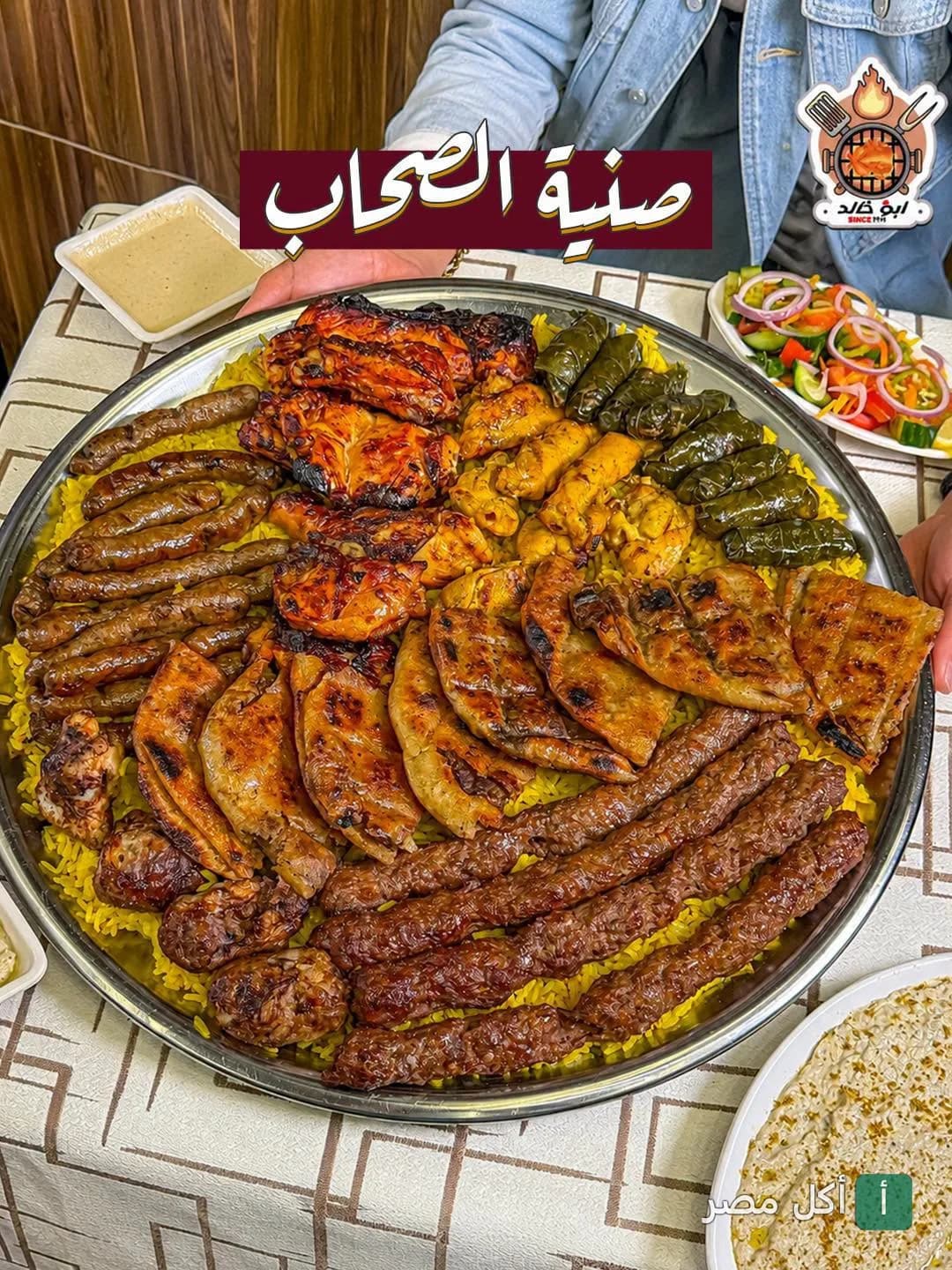 صينية مشاوي مشكلة من كبابجي أبو خالد في عين شمس تضم كباب وكفتة وطرب وورق عنب على أرز أصفر.