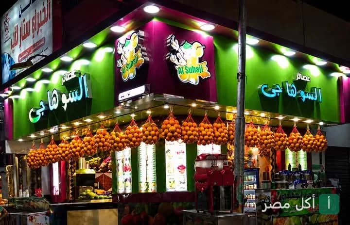 واجهة محل عصائر السوهاجي في عين شمس معروض عليها أكياس برتقال طازج.