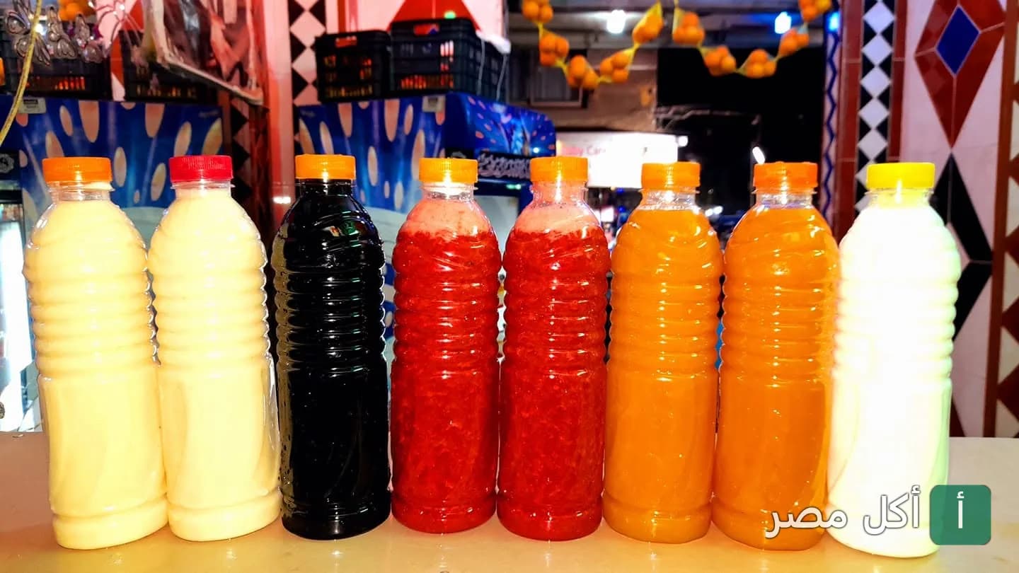 زجاجات عصائر طازجة متنوعة الألوان في محل عصائر السوهاجي بعين شمس.