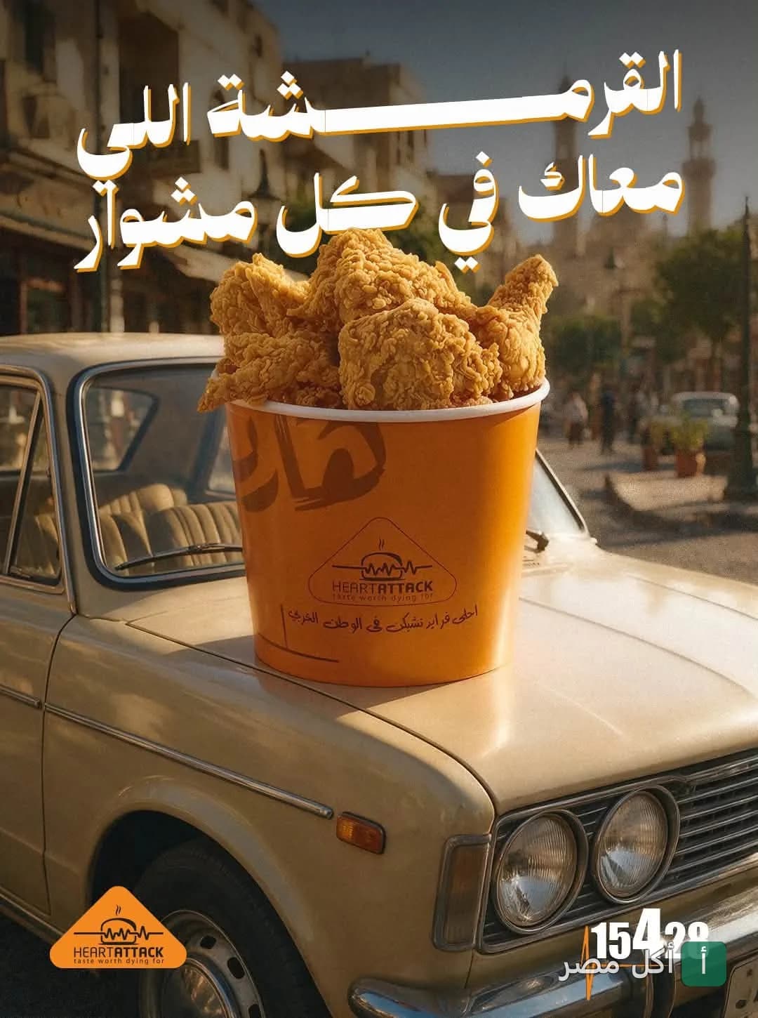 دلو دجاج مقلي من هارت اتاك موضوع على مقدمة سيارة كلاسيكية في شارع بمدينة عين شمس.