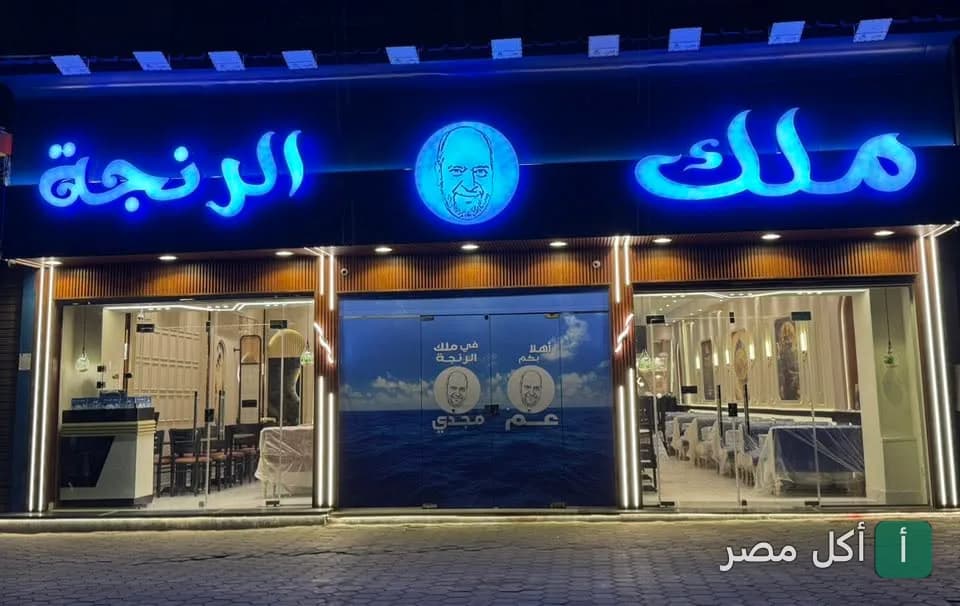واجهة مطعم ملك الرنجة في منطقة أبو حرباية بالدرب الأحمر، تظهر لافتة مضيئة باللون الأزرق ومدخل المطعم.