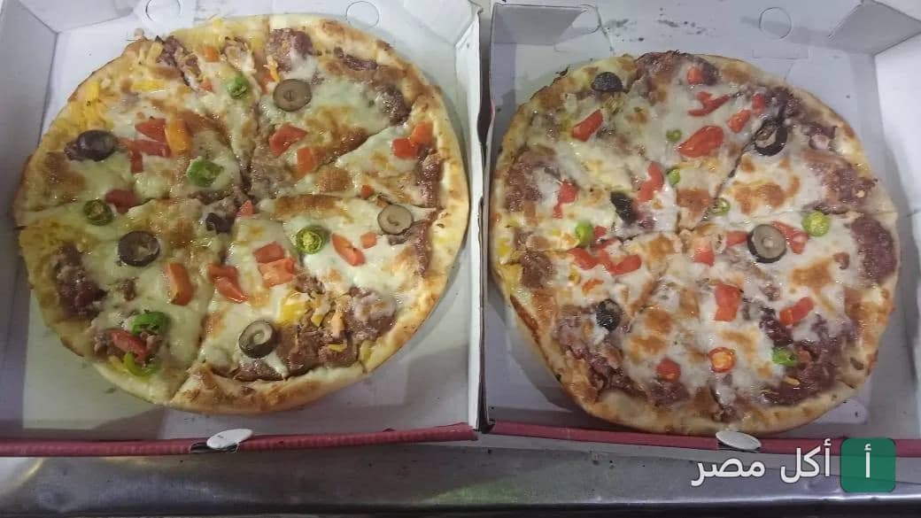 بيتزتين في علب كرتون من مطعم بيتزا الزعيم في الدرب الأحمر، مغطاة بالجبنة والزيتون والفلفل.