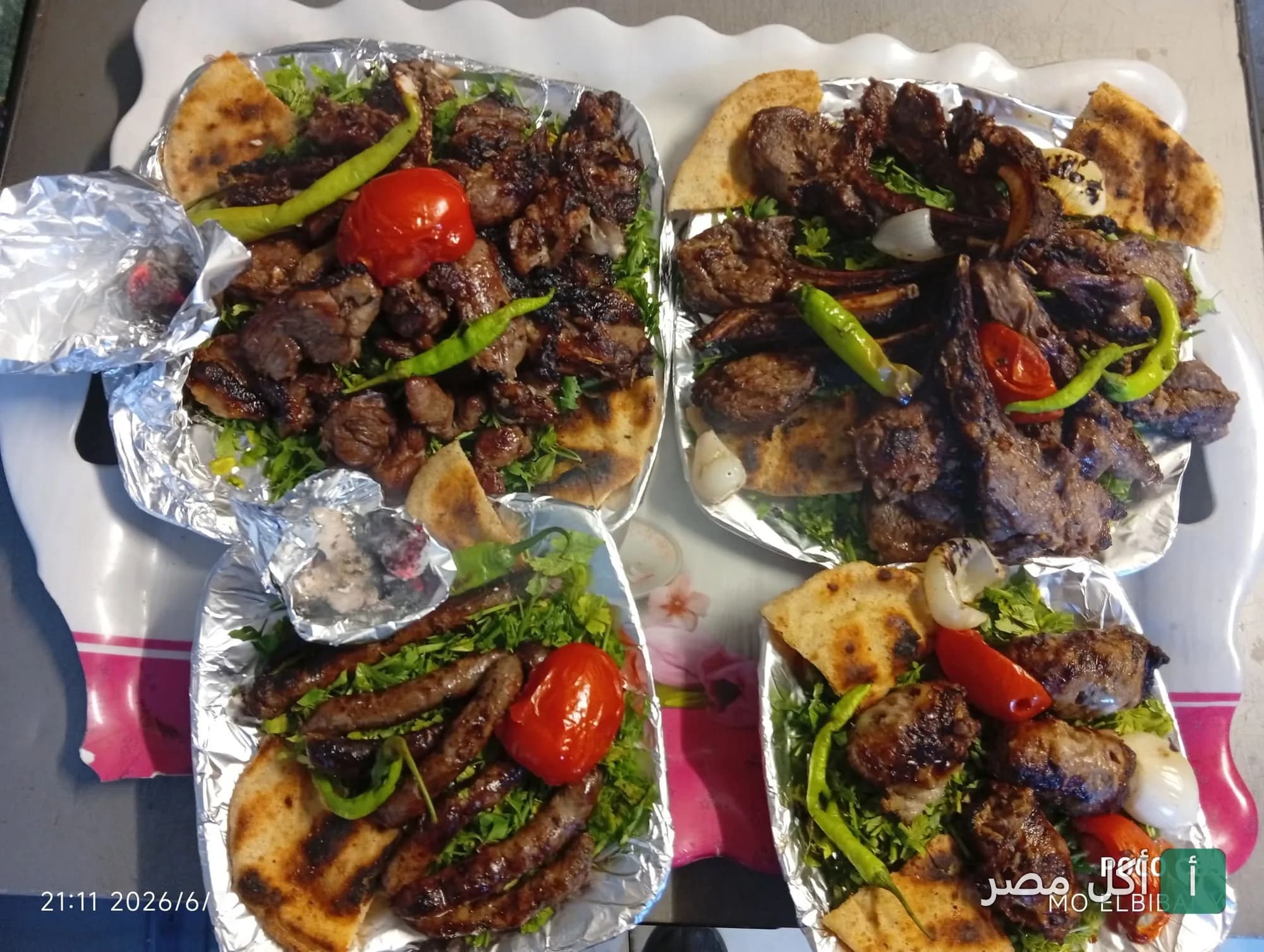 أطباق مشويات متنوعة من كبابجي البيباني بالدرب الأحمر، تضم كباب وكفتة وسجق مشوي مع الخضار والخبز.