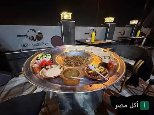 صينية مشويات متنوعة ومقبلات على طاولة في مطعم كبابجي الفتح بالدرب الأحمر.