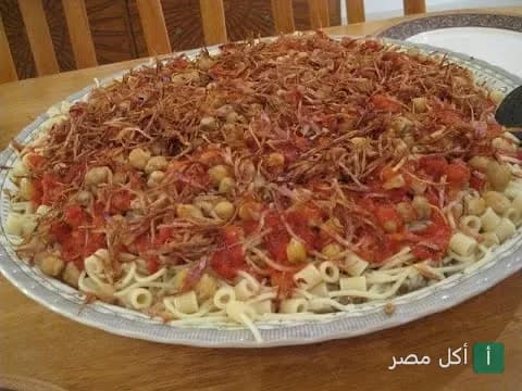 طبق كشري مصري تقليدي مغطى بالبصل المقرمش والحمص في مطعم كشري الجمهورية بالأزهر.
