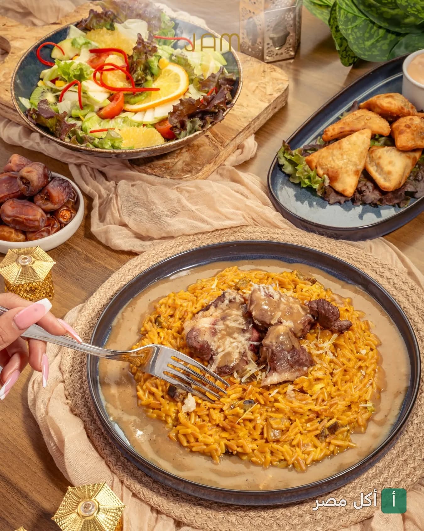 مائدة رمضانية متنوعة في جام لاونج بالخليفة تضم طبق أرز باللحم وسلطة وسمبوسك وتمور.