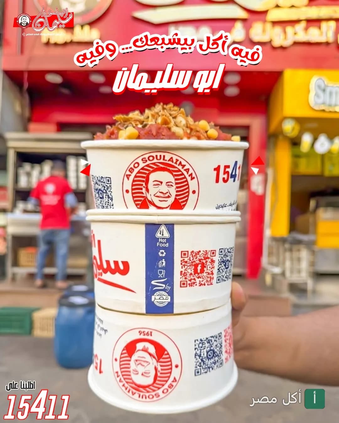 ثلاث علب مكرونة فوق بعض تحمل شعار أبو سليمان أمام واجهة المطعم في الخليفة