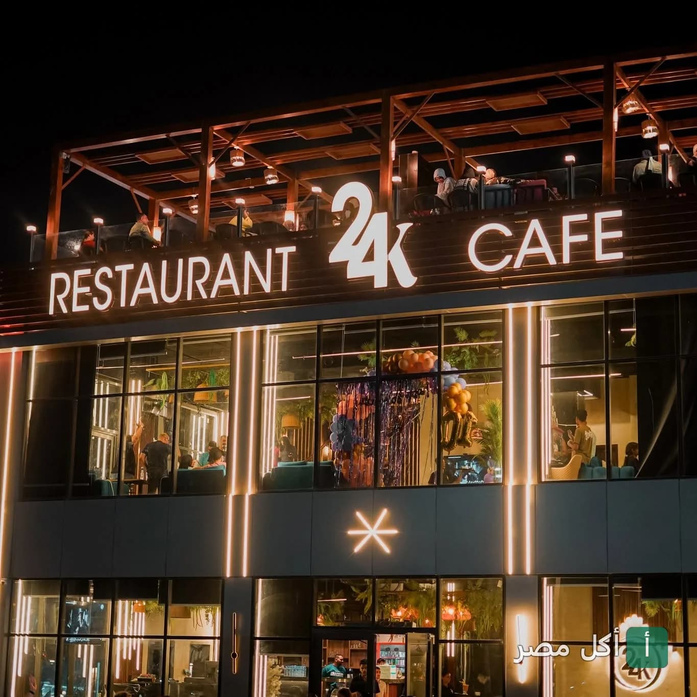 واجهة مطعم وكافيه 24K في الخليفة ليلاً مع إضاءة خارجية وجلسات روف.