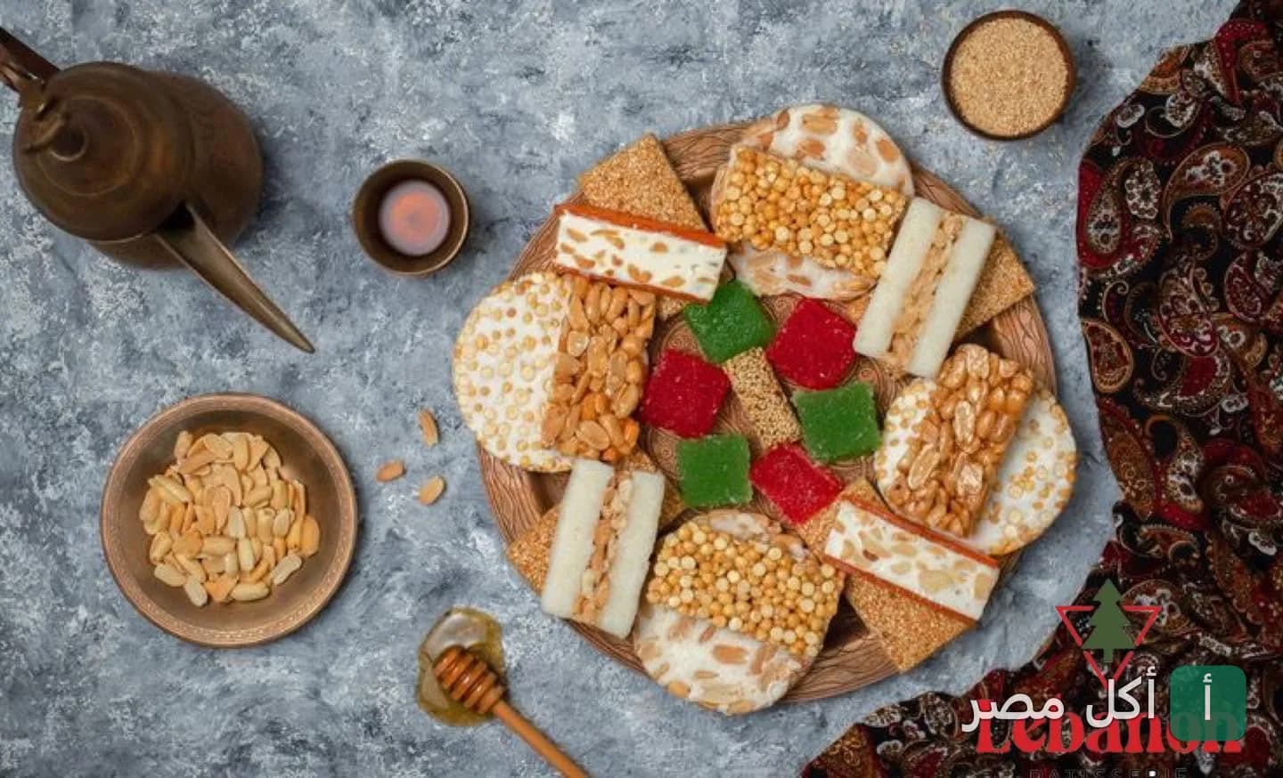 تشكيلة من حلاوة المولد التقليدية في طبق مزخرف مع إبريق نحاسي في مطعم لبنان بالخليفة.