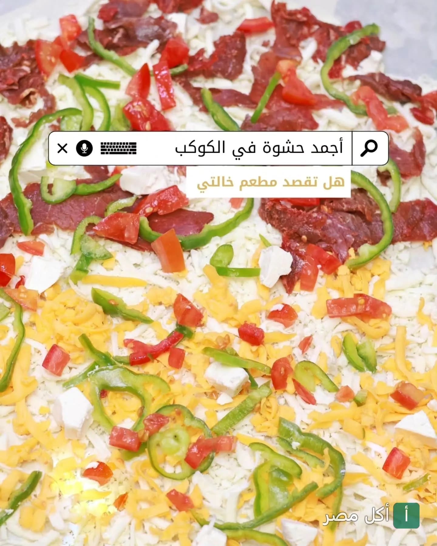 بيتزا غير مطهية مغطاة بالجبن والفلفل الأخضر والطماطم واللحم في مطعم خالتي بالخليفة.