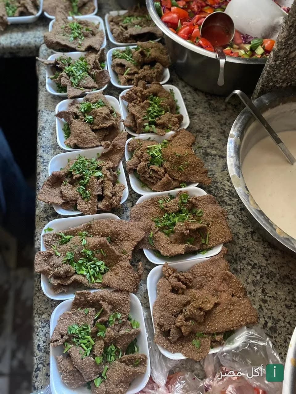 أطباق كبدة مقلية طازجة مزينة بالبقدونس في مطعم أبو عمرو كبده ومخ بالخليفة