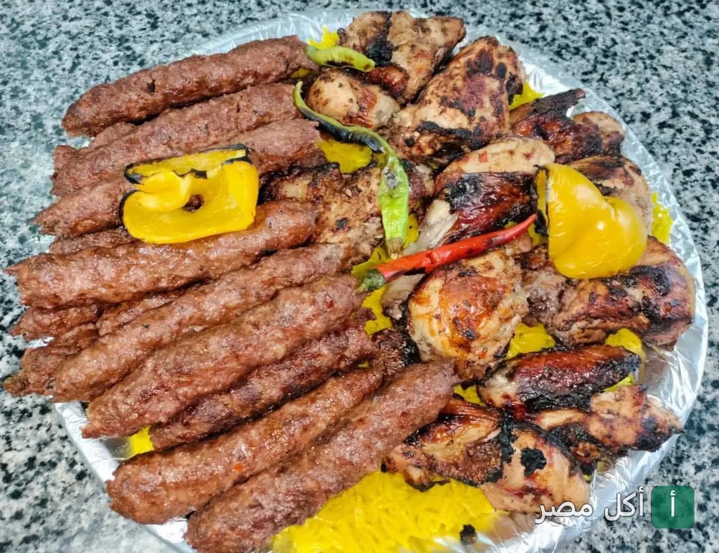 طبق مشويات مشكل من كفتة ودجاج مشوي مع أرز أصفر وفلفل ألوان في مطعم الاكيل بالخليفة