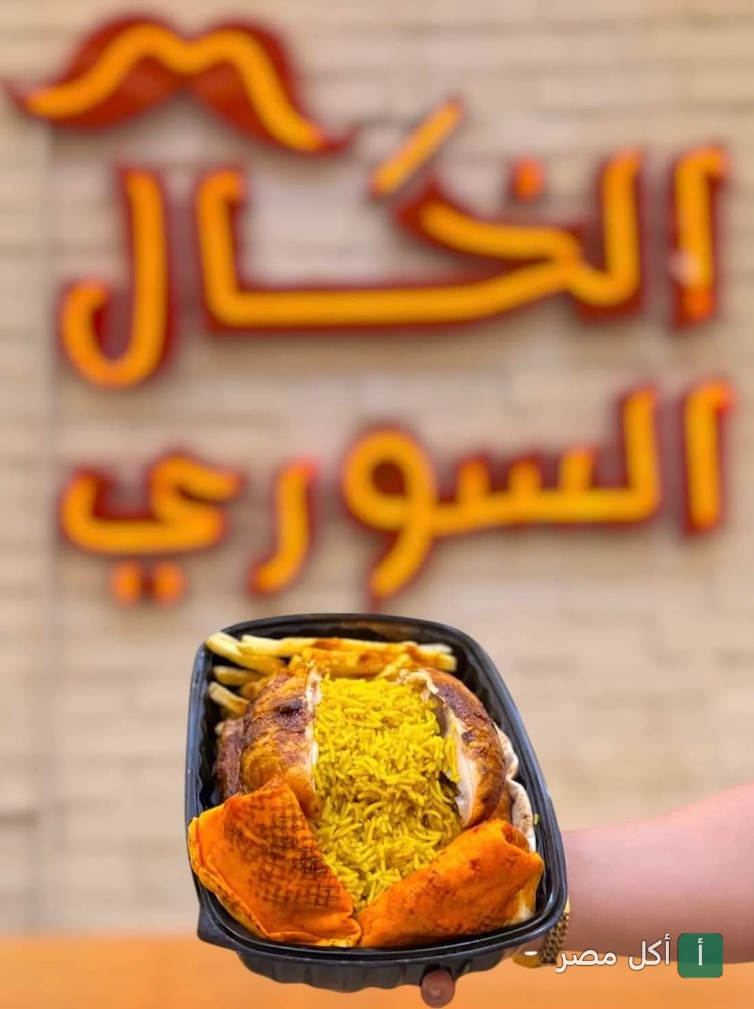 وجبة دجاج مشوي مع أرز أصفر وبطاطس في مطعم الخال السوري بالخليفة