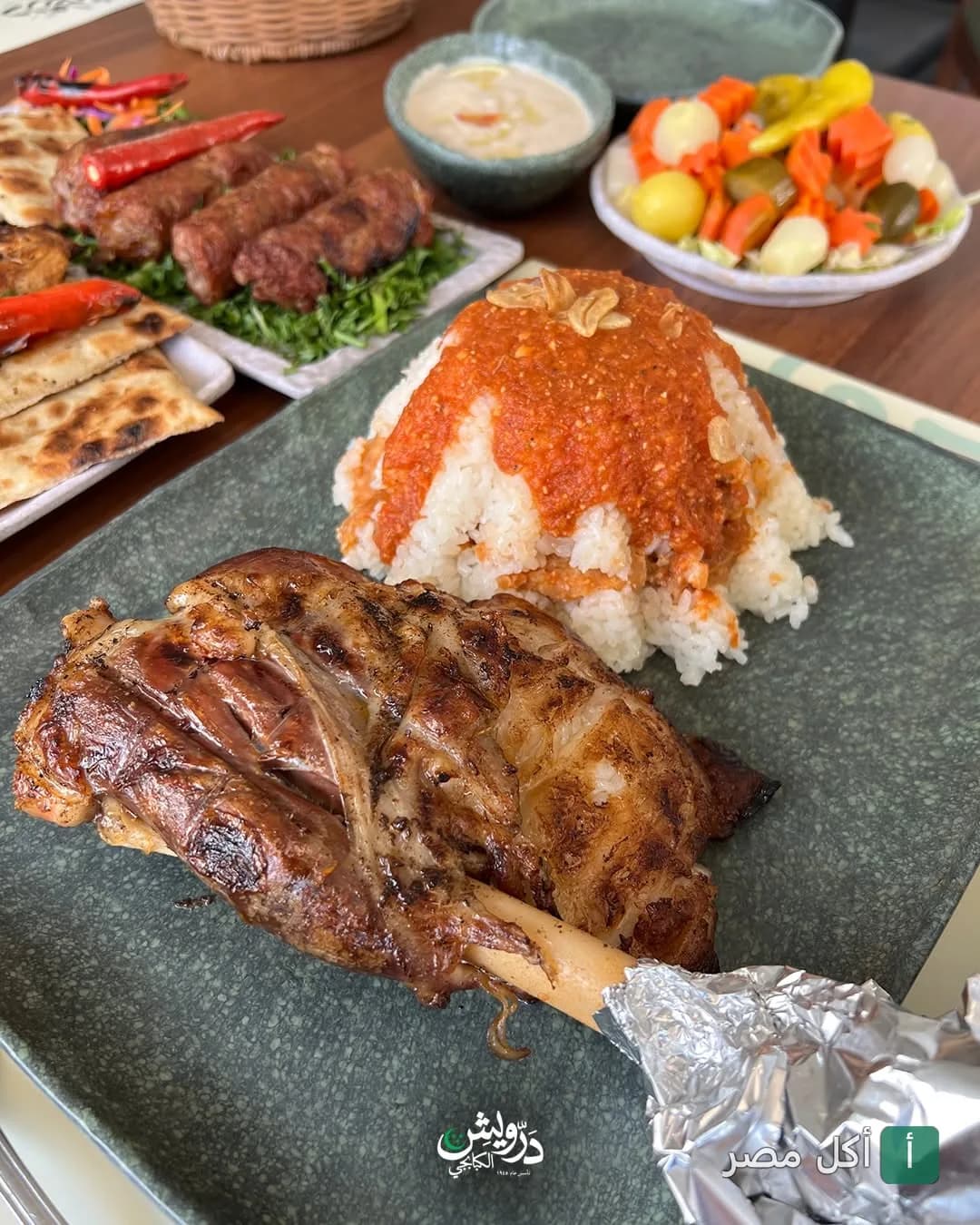 طبق موزة ضاني مشوية مع أرز بصلصة الطماطم في مطعم الحاج درويش للمشويات بالخليفة.