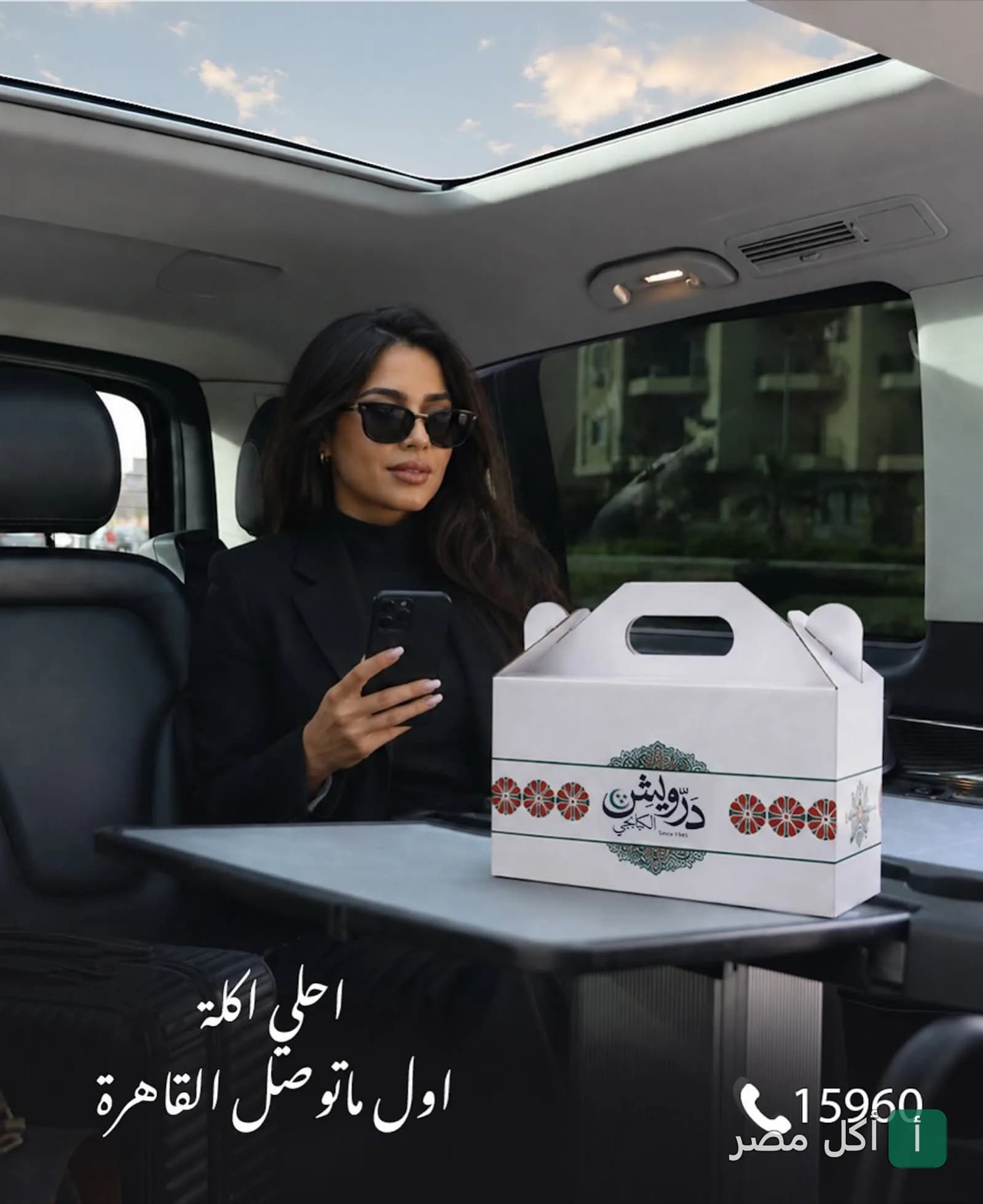 زبونة في سيارة تحمل علبة تيك أواي من مطعم الحاج درويش للمشويات بالخليفة.