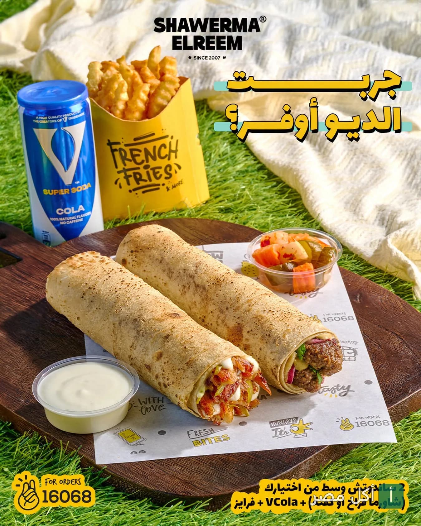 عرض وجبة شاورما الريم المكونة من سندوتشات شاورما مع بطاطس مقلية ومشروب غازي على طبق خشبي.