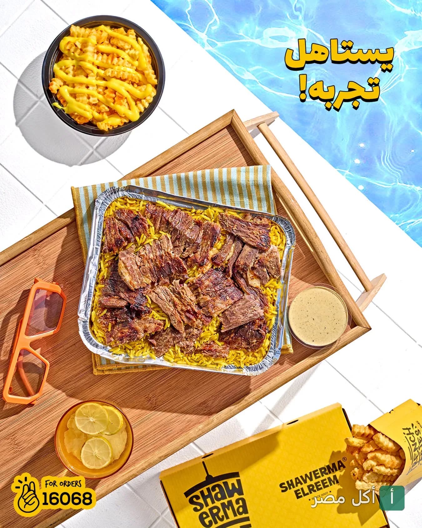 وجبة شاورما لحم مع أرز أصفر وبطاطس محمرة من شاورما الريم بجانب حمام سباحة.
