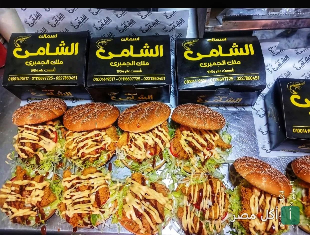 ساندوتشات جمبري مقلي بصوص مميز من مطعم الشامي للأسماك مع علب التغليف الخاصة بهم.