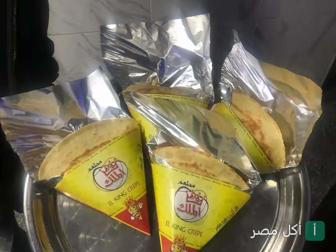ثلاث قطع كريب في ورق تغليف أصفر يحمل شعار مطعم الملك في الخليفة.