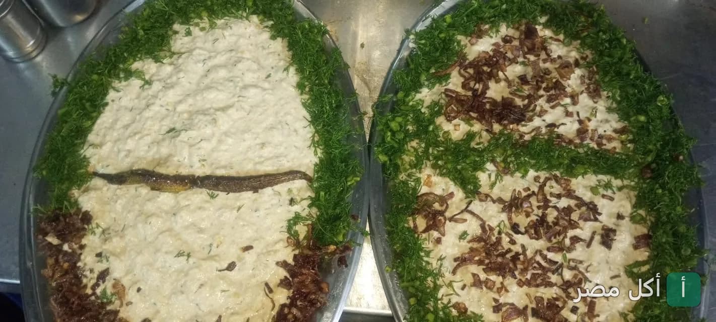 أطباق بابا غنوج مزينة بالشبت والبصل المحمر في مطعم الملك بالخليفة.