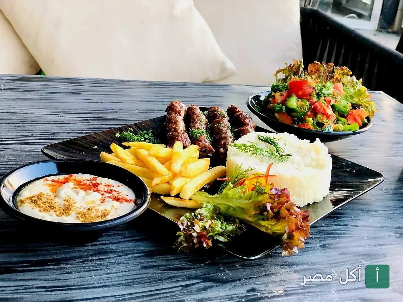 طبق مشاوي كفتة مع أرز وبطاطس مقلية وسلطة وطحينة في بيكاسو كافيه