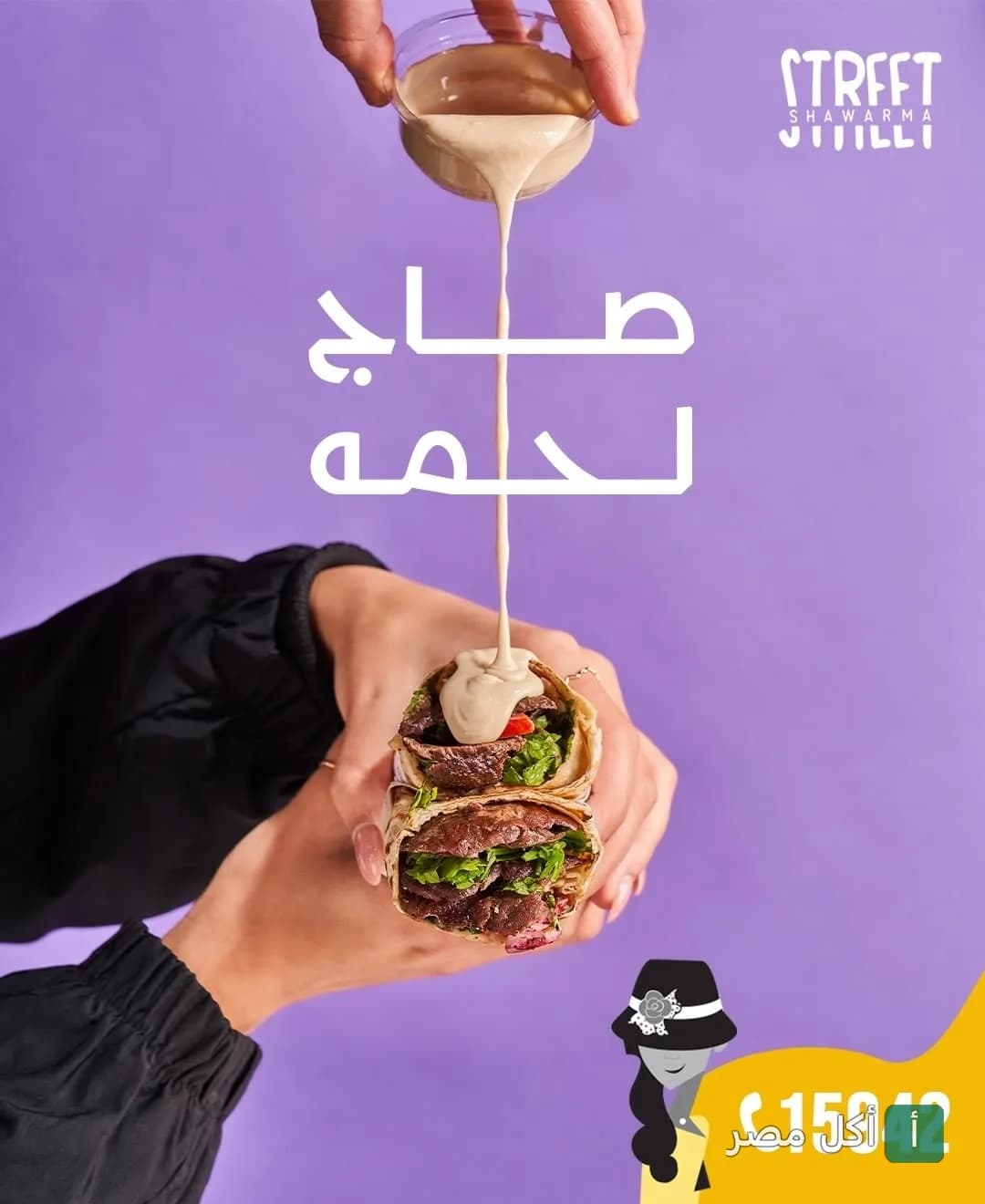 شخص يصب صوص الطحينة على ساندوتش شاورما لحم صاج من مطعم شاورما ستريت في 6 أكتوبر.