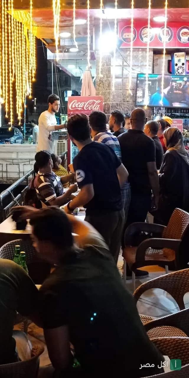 زبائن يجلسون في منطقة الجلوس الخارجية لمطعم يونايتد ستيت أوف كبدة في 6 أكتوبر ليلاً.