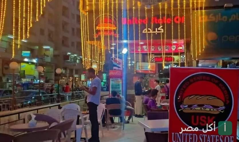 واجهة مطعم يونايتد ستيت أوف كبدة في 6 أكتوبر مع إضاءة خارجية وطاولات للجلوس في الهواء الطلق.