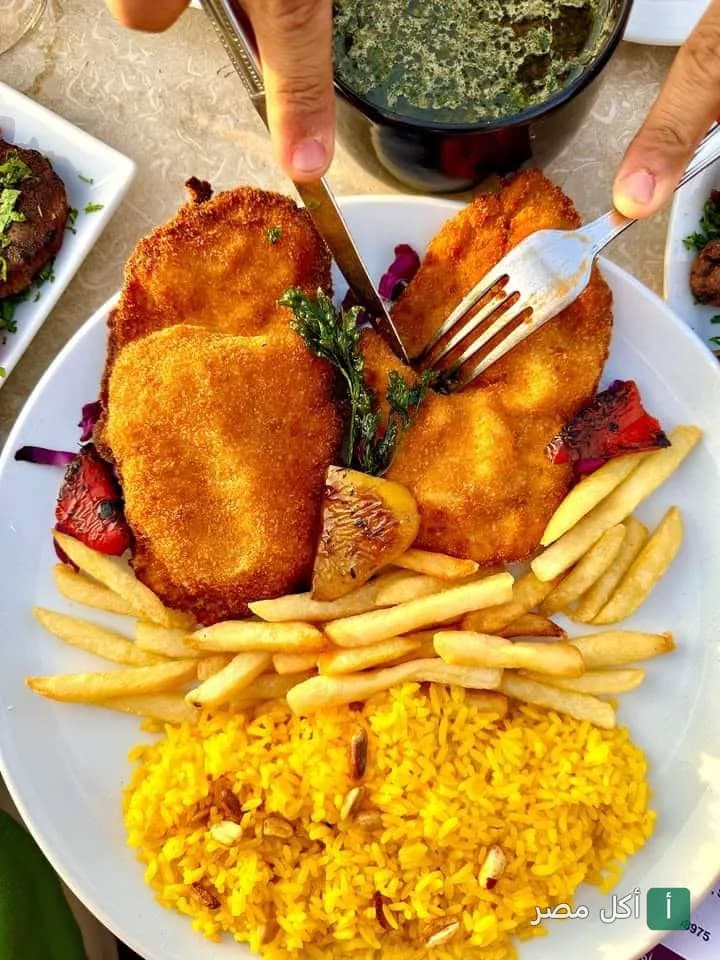 طبق بانيه مقرمش مع أرز أصفر وبطاطس محمرة في هيفين لاونج آند روف توب فيو بنزلة السمان.