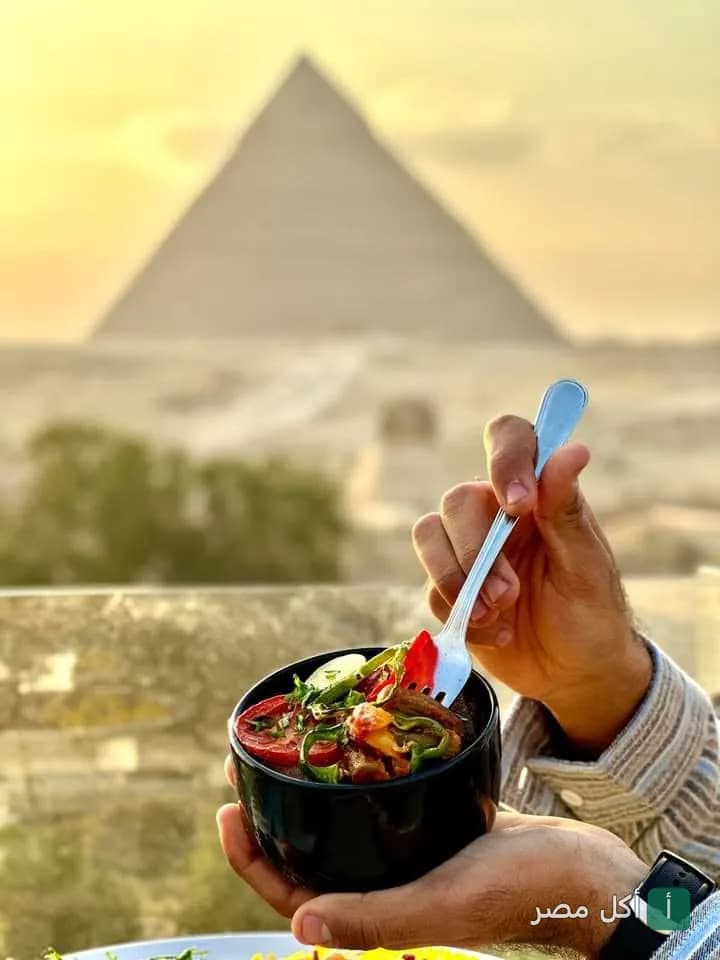 طبق طعام في هيفين لاونج بنزلة السمان مع إطلالة مباشرة على أهرامات الجيزة وقت الغروب.
