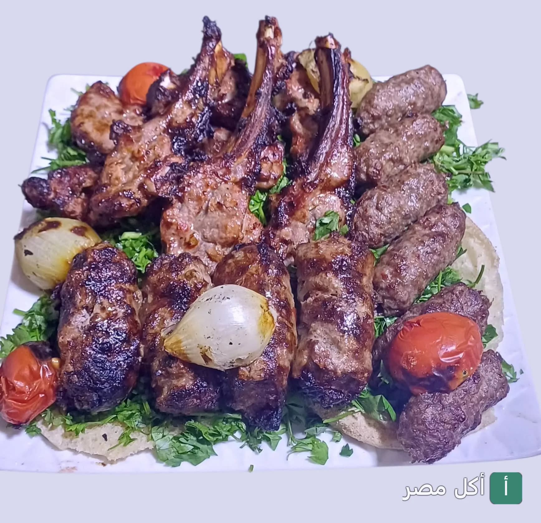 طبق مشاوي مشكل من الكبابجي أبو عبدو بالأهرام، يحتوي على ريش ضاني وكفتة مشوية مع طماطم وبصل مشوي على بقدونس.