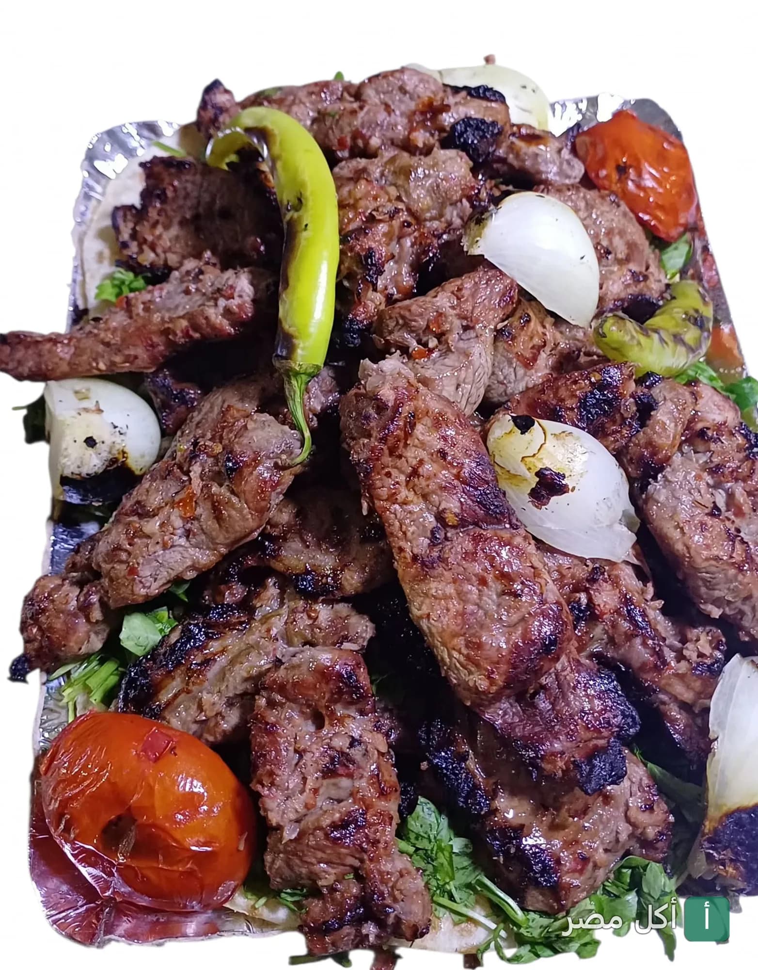 طبق مشويات مشكل من الكبابجي أبو عبدو بالأهرام، يضم قطع لحم مشوية مع بصل وطماطم وفلفل أخضر.