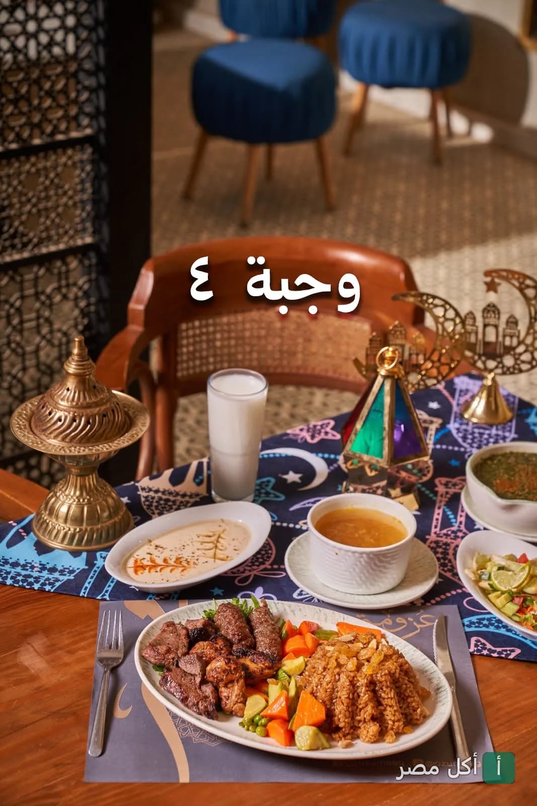 مائدة رمضانية في مطعم عزومة تضم وجبة مشويات متنوعة مع أرز وخضروات ومقبلات.
