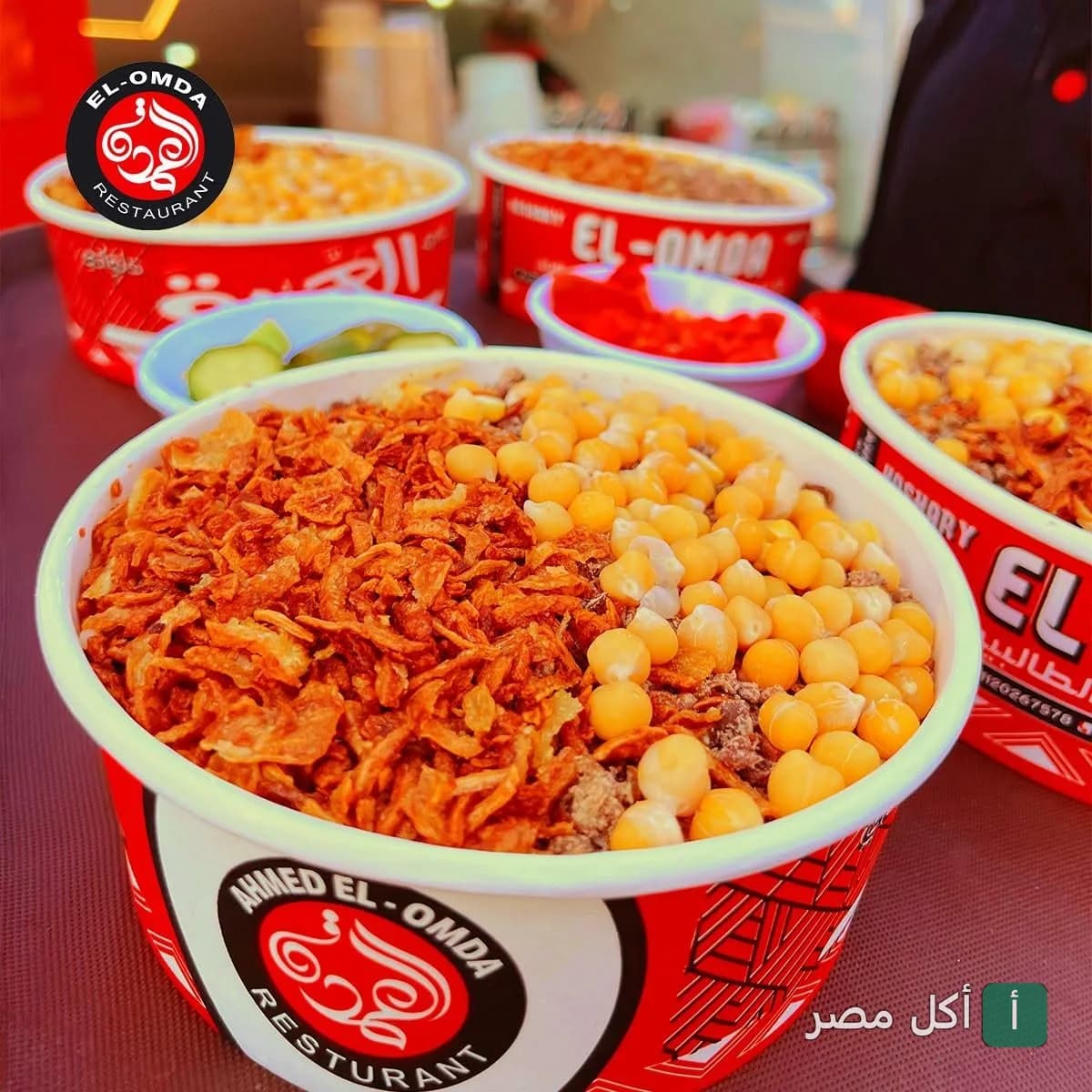 أطباق كشري مصري جاهزة للتقديم في عبوات كشري العمدة الحمراء المميزة.