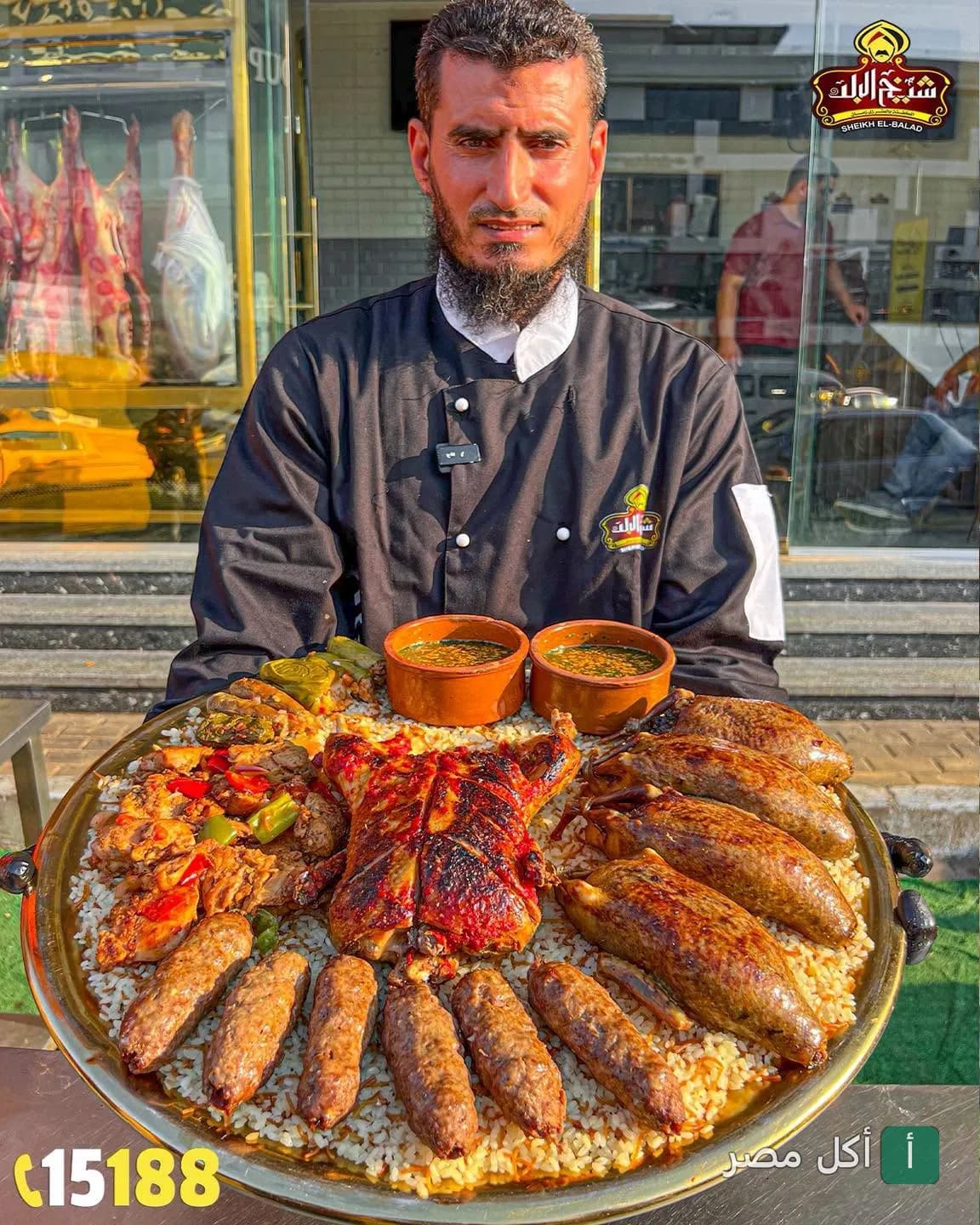 شيف مطعم شيخ البلد في بولاق الدكرور يقدم صينية مشويات كبيرة تحتوي على بط ومحشي وحمام وكفتة.