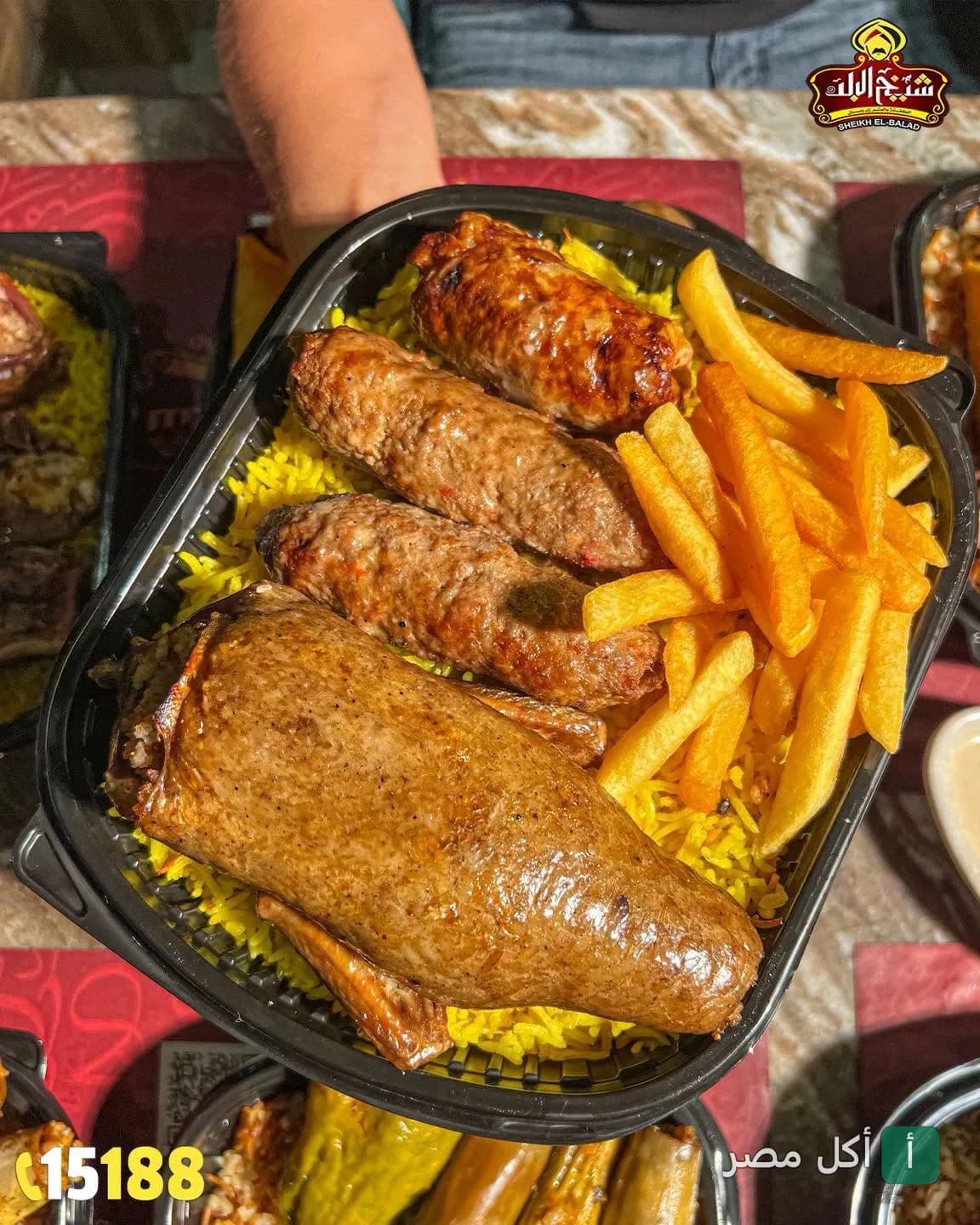 وجبة مشويات من مطعم شيخ البلد في بولاق الدكرور تحتوي على حمام محشي وكفتة وأرز أصفر وبطاطس محمرة.