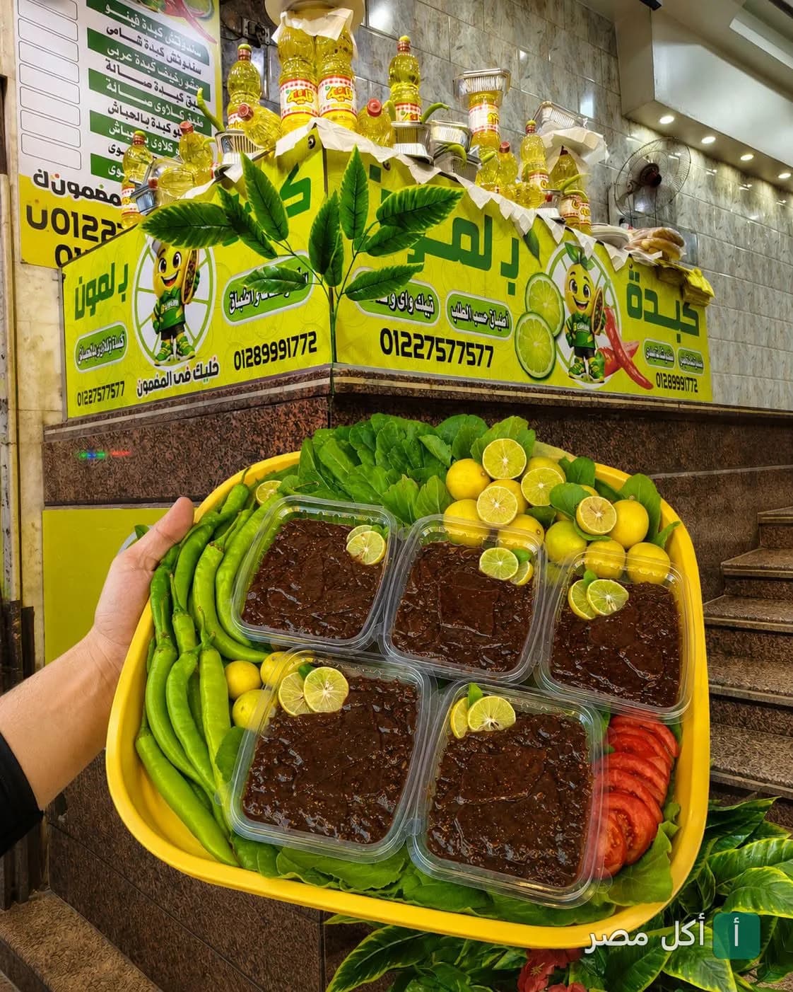 صينية تحتوي على علب كبدة جاهزة للتقديم مع الليمون والفلفل الأخضر في مطعم كبدة ب لمون ببولاق الدكرور.