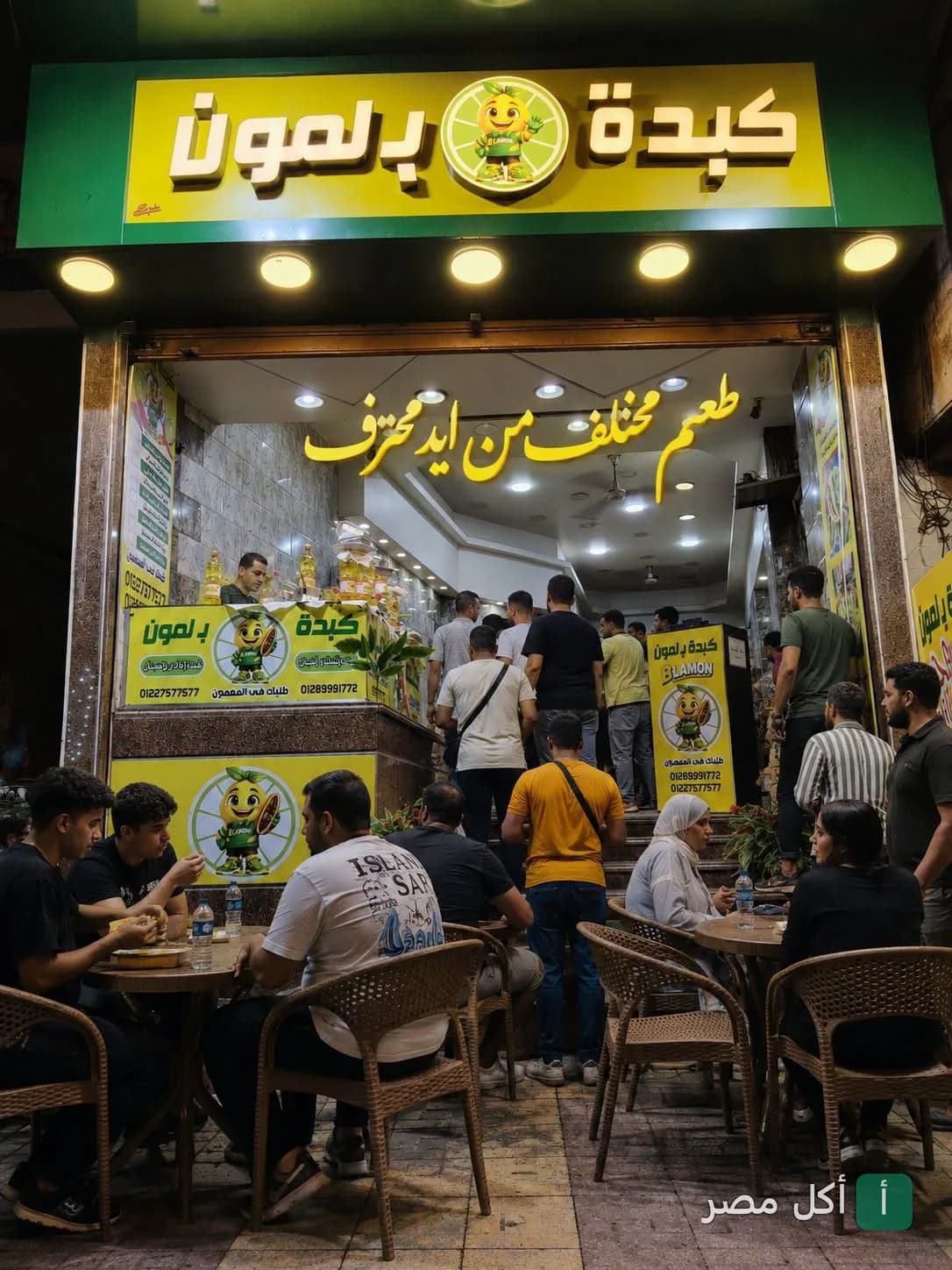 واجهة مطعم كبدة ب لمون في بولاق الدكرور مع زبائن يجلسون في الخارج.