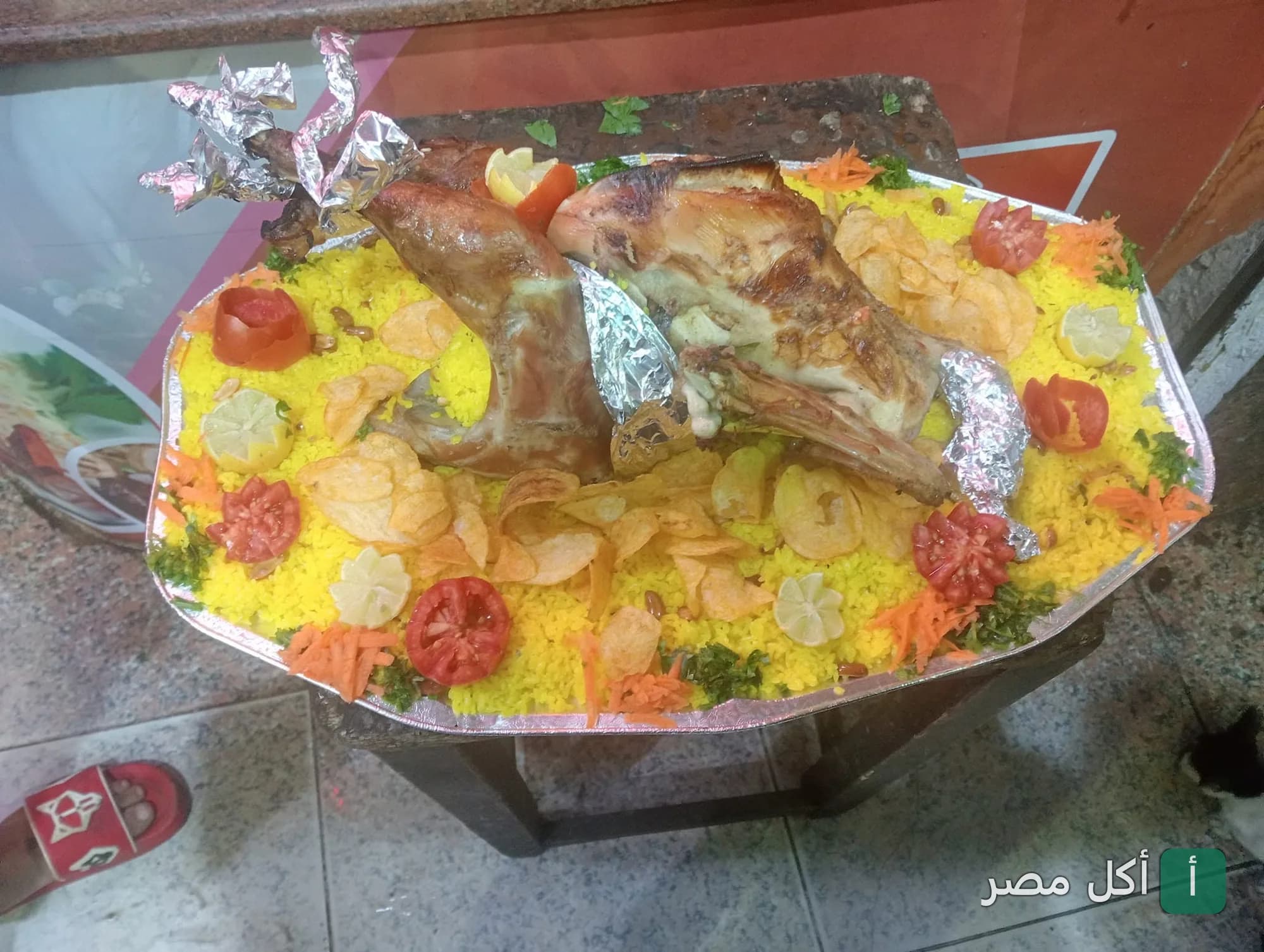 طبق كبير من الأرز الأصفر مع لحم مشوي مزين بشرائح البطاطس والطماطم في كبابجي الشحات ببولاق الدكرور.