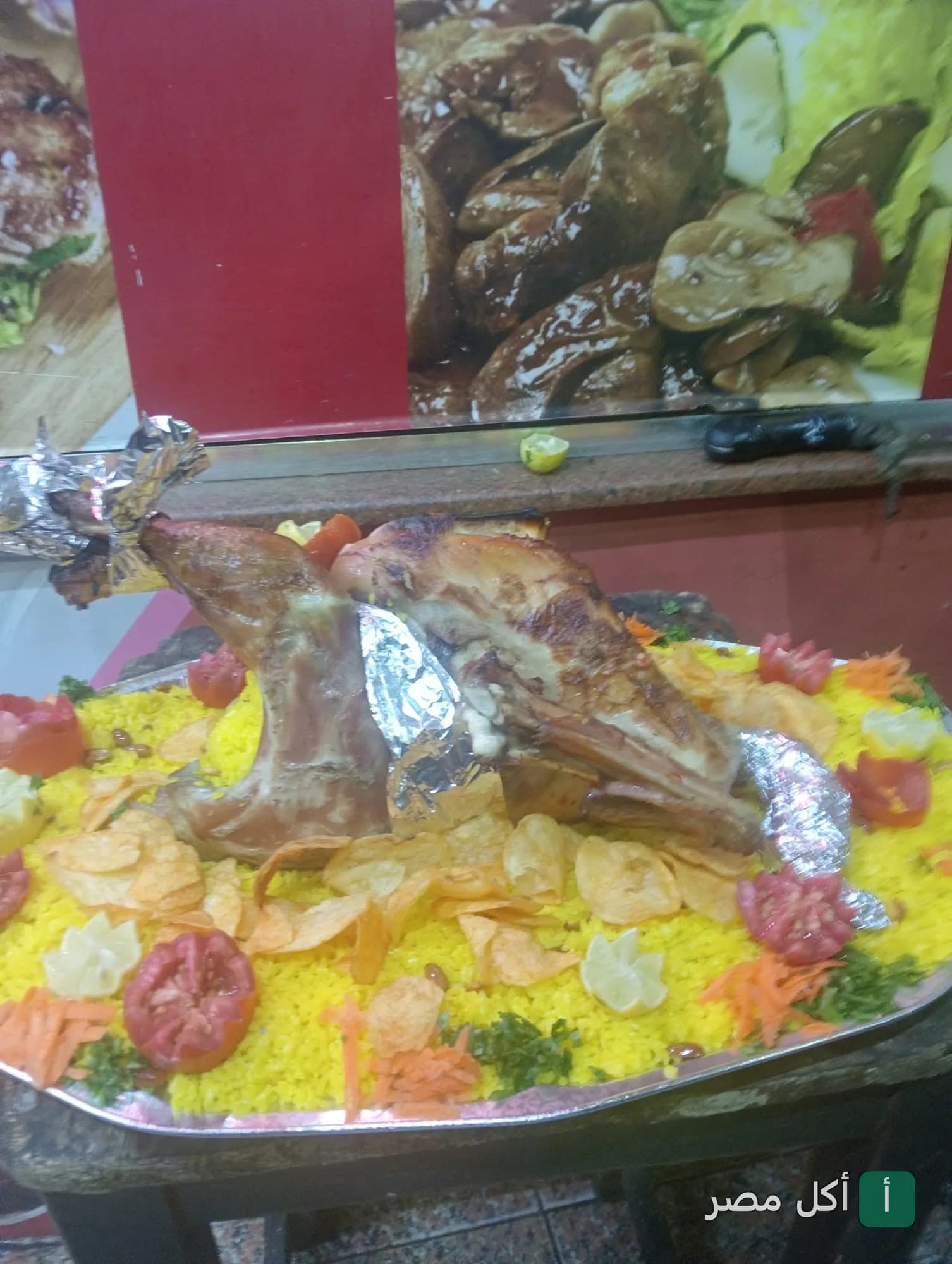 طبق كبير من الأرز الأصفر مع لحم مشوي مزين بشرائح الطماطم والبطاطس في كبابجي الشحات ببولاق الدكرور.