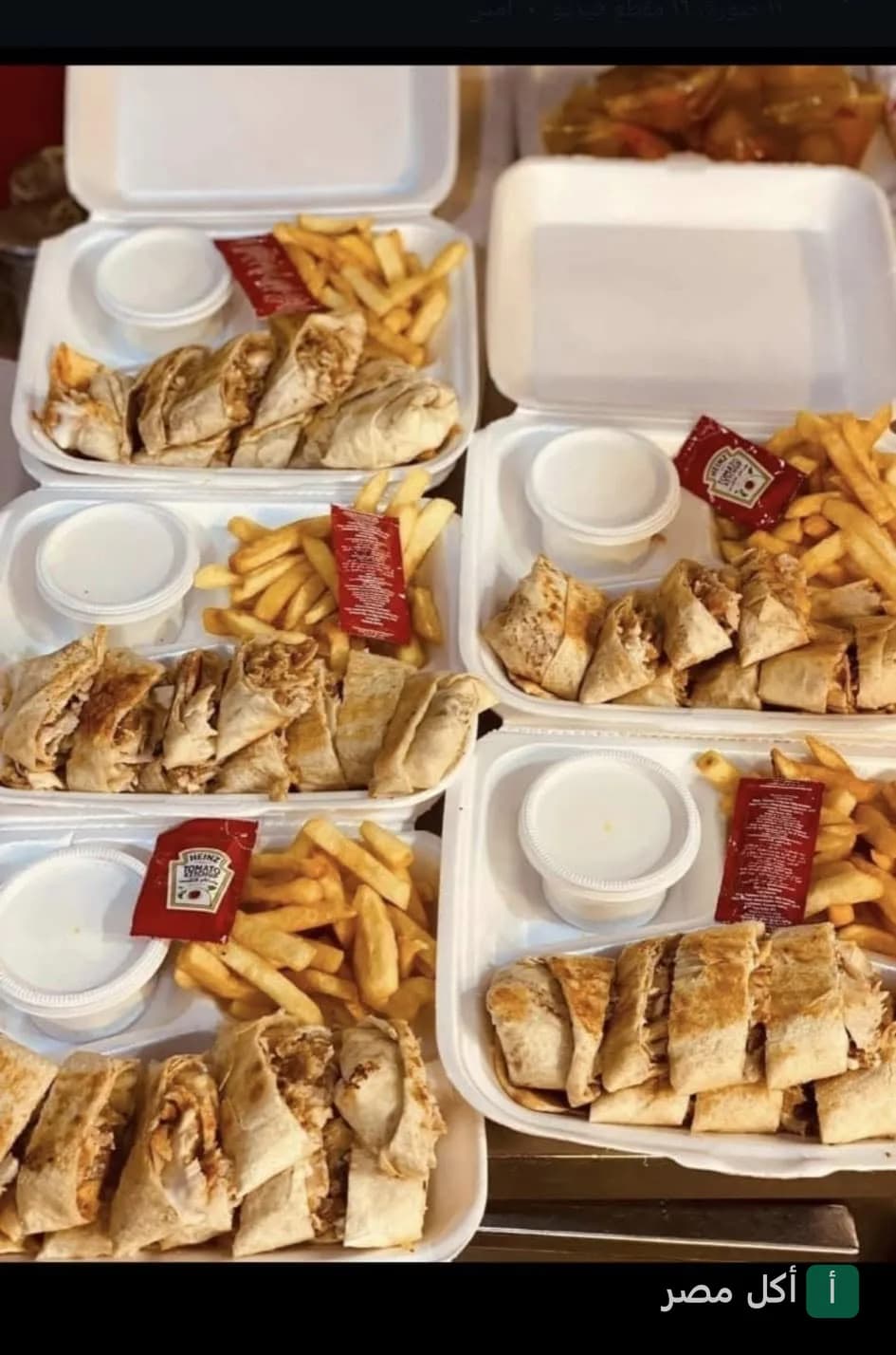 وجبات شاورما مقطعة مع بطاطس محمرة وصوص في علب تيك أواي من مطعم مستر روما كريب اند سوري ببولاق الدكرور.