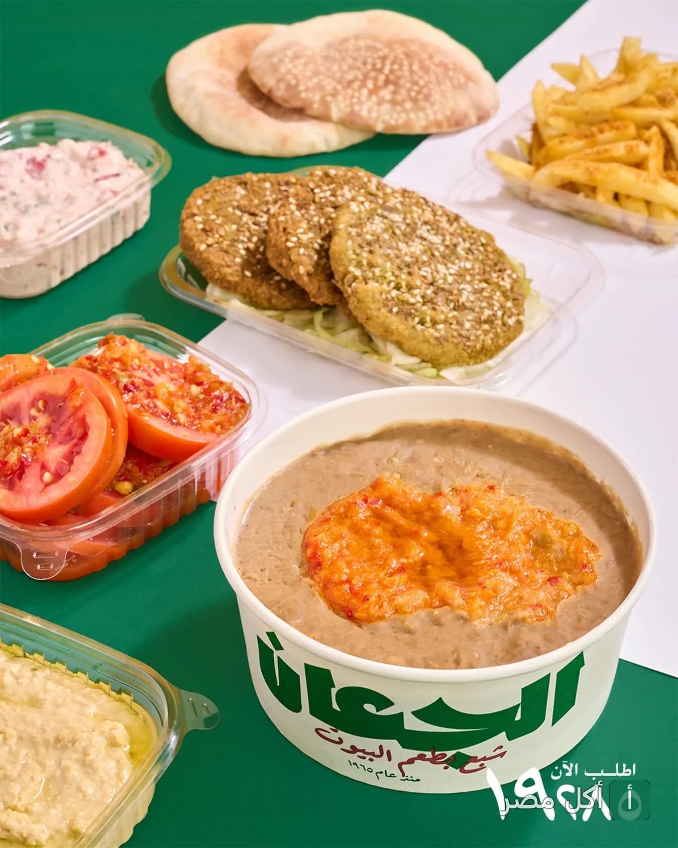 تشكيلة فطور مصري تقليدي من مطاعم الجعان في بولاق الدكرور، تتضمن فول بالطحينة وطعمية وعيش بلدي.