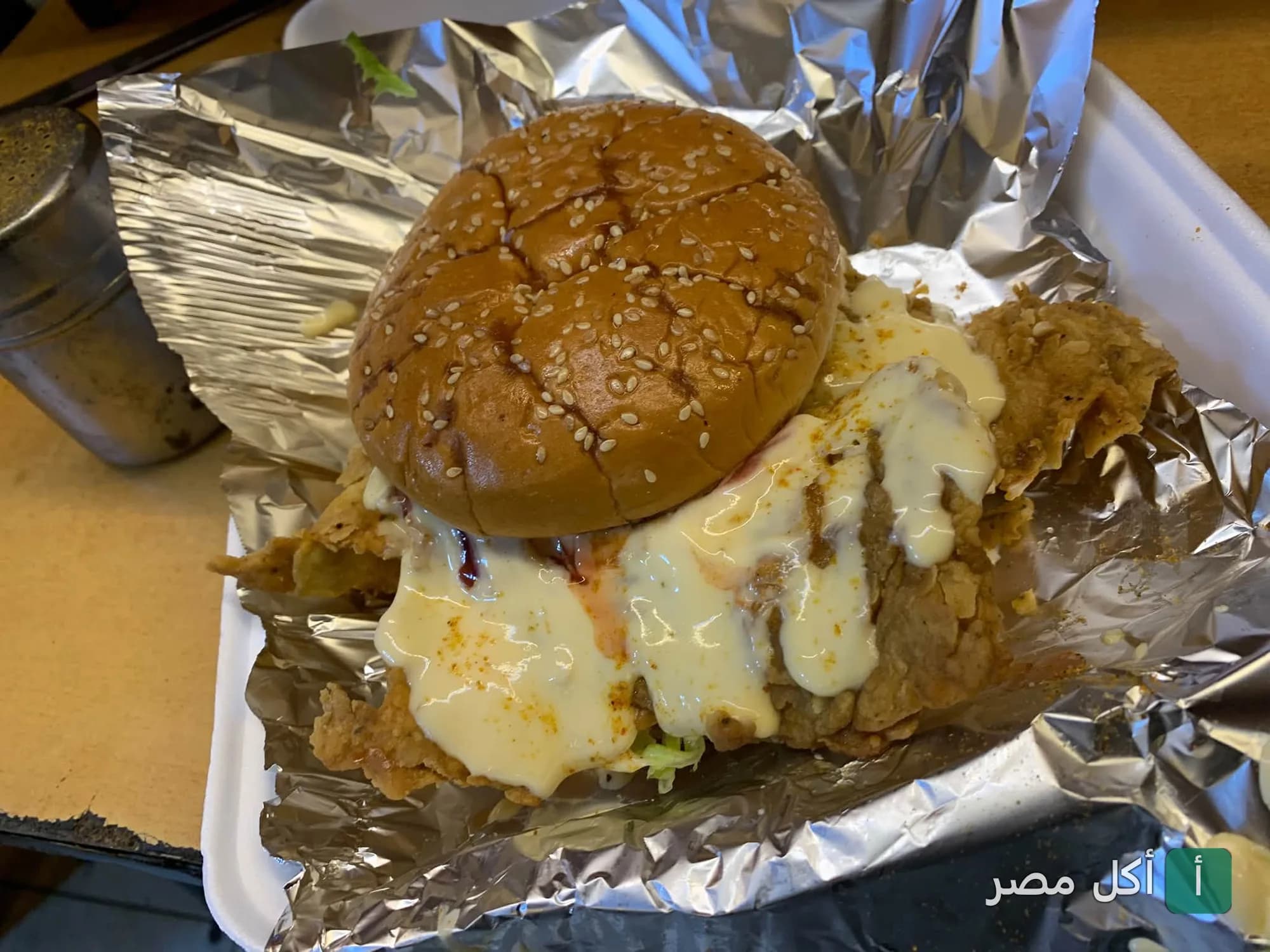 ساندوتش دجاج مقلي مغطى بصوص الجبن في مطعم مستر زيزو ببولاق الدكرور