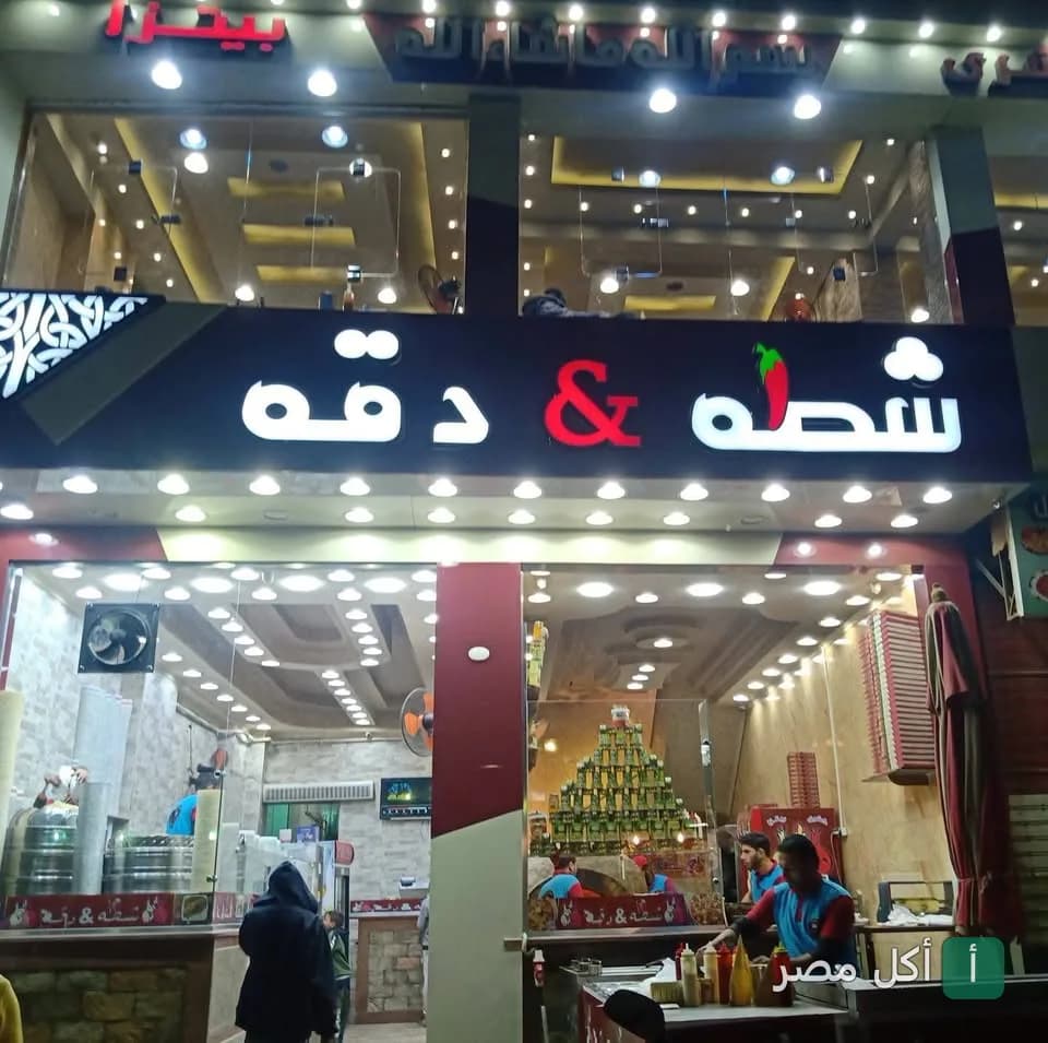 واجهة مطعم شطة في بولاق الدكرور مع لافتة مضيئة تظهر اسم المطعم وشعار الفلفل الحار.
