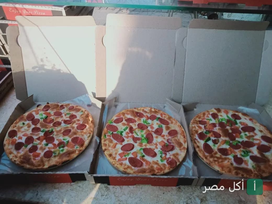 ثلاث بيتزا بالسلامي والفلفل في علب كرتون من مطعم بيتزا فطائر الزعيم في بولاق الدكرور