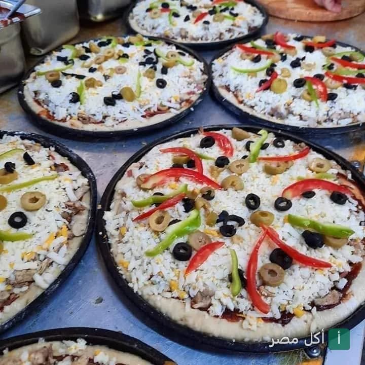 بيتزا طازجة بالجبنة والزيتون والفلفل في مطعم بيتزا فطائر الزعيم ببولاق الدكرور