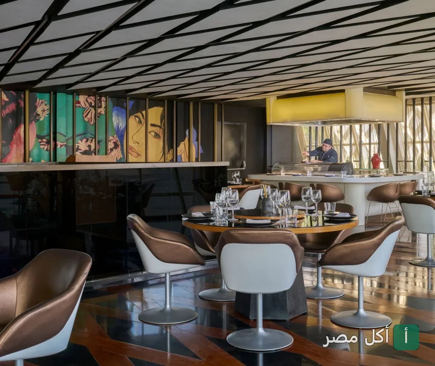 تصميم داخلي أنيق لمطعم نايرُو في الجيزة، يظهر طاولات عصرية ومنطقة تحضير الطعام.